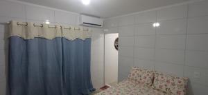 un bagno con una tenda da doccia blu e un divano di Taberna dos Castilho 1 a Bertioga