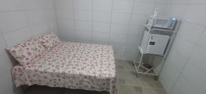 una piccola camera con un letto con una coperta a fiori di Taberna dos Castilho 1 a Bertioga Altre 5 foto