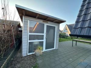 ein kleiner Schuppen mit einer großen Glasschiebetür in der Unterkunft Ferienhaus am Ringwall 19 in Duhnen