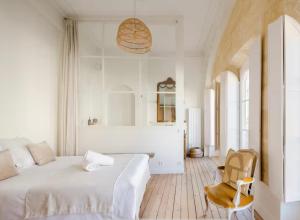 een witte slaapkamer met een bed en een stoel bij Splendide Appartement a coté de la Mer Calme 2 Room Wifi Tramway in Nice