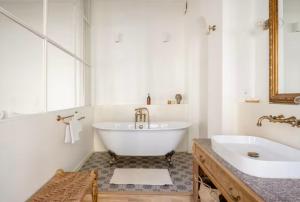 een witte badkamer met een bad en een wastafel bij Splendide Appartement a coté de la Mer Calme 2 Room Wifi Tramway in Nice