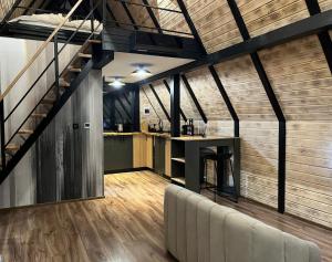 a loft kitchen with a staircase and a bar at A-frame Boema in Cîmpu lui Neag