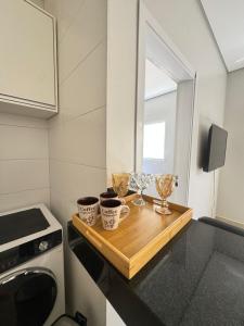 een keuken met een tafel met twee kopjes en een magnetron bij Magnolia Flat in Formosa