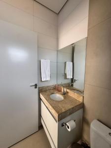 een badkamer met een wastafel en een spiegel bij Magnolia Flat in Formosa