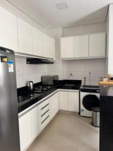 een keuken met witte kasten en zwarte aanrechtbladen bij Magnolia Flat in Formosa