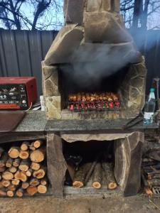 a stone oven with smoke coming out of it at Guesthouse Zaqara in Borjomi