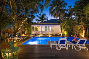 una persona sdraiata su una terrazza accanto alla piscina di Papa's Hideaway a Key West