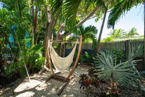 un'amaca in un giardino con palme e una recinzione di Papa's Hideaway a Key West Altre 31 foto