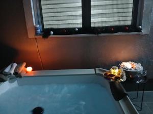 una vasca da bagno con una candela e una finestra di Vila Obradovic ad Arilje