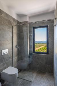 a bathroom with a shower and a toilet and a window at Acros Resort in Vlorë