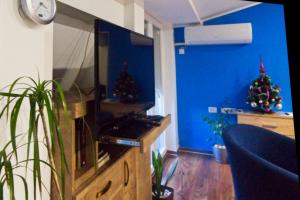 a living room with two christmas trees and a television at Stan na dan Flower in Šabac