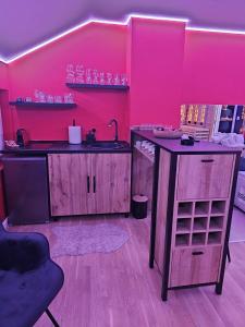 a pink kitchen with a sink and a counter at Apartman Fantazy spa BDSM in Zemun