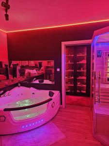 a bathroom with a tub with pink lights in it at Apartman Fantazy spa BDSM in Zemun +23 photos