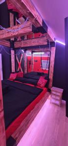 a bedroom with a large wooden bed with red pillows at Apartman Fantazy spa BDSM in Zemun