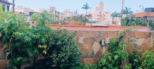 a stone wall with banana trees and buildings at Condomínio Sol de Verao in Florianópolis