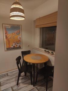een keuken met een tafel en stoelen en een raam bij Amos Coastal Escape Studio - Hanko in Hanko +5 foto's