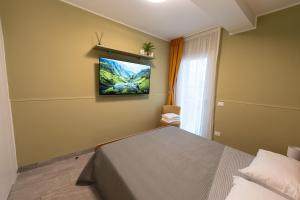 a bedroom with a bed and a tv on the wall at B&B Maison Sophie SOVERATO MARINA in Soverato Marina