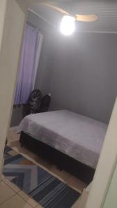 una camera con letto e luce sul soffitto di casa Magalhães a Laguna