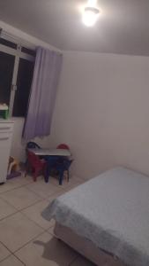 una camera da letto con un letto, un tavolo e una finestra di casa Magalhães a Laguna