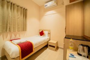 a small bedroom with a bed in a room at Aura Heaven in Thanjāvūr