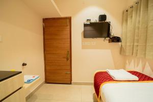 a room with a bed and a wooden door at Aura Heaven in Thanjāvūr