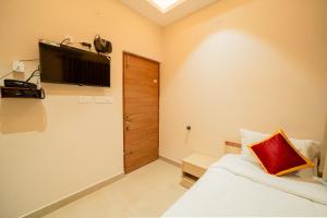 a bedroom with a bed and a television on the wall at Aura Heaven in Thanjāvūr +14 photos