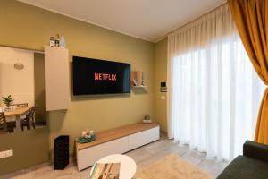 a living room with a television on the wall at B&B Maison Sophie SOVERATO MARINA in Soverato Marina
