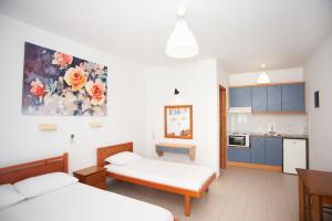 una camera con due letti e una cucina di Rosa's Beach Studios a Lourdata Altre 75 foto