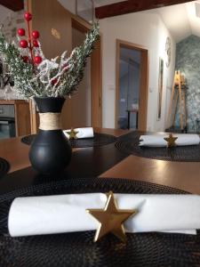 ein Esstisch mit einer schwarzen Vase mit Sternen darauf in der Unterkunft Apartman Megi & studio apartman Tomi - SELF CHECK IN in Krapina