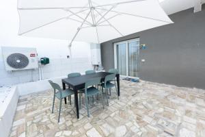 a dining room with a table and chairs and an umbrella at B&B Maison Sophie SOVERATO MARINA in Soverato Marina