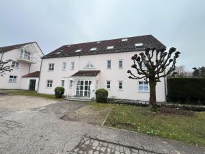 een wit huis met een boom ervoor bij Fewo Eirich in Günzburg