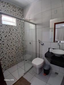 een badkamer met een douche, een toilet en een wastafel bij Pousada Portal do Peruaçu in Januária