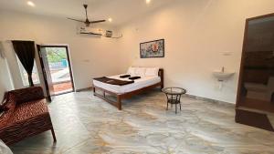 une chambre avec un lit, une table et un lavabo dans l'établissement La Nature Retreat, à Kuilapayam
