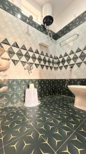 La salle de bains est pourvue de carrelage noir et blanc et d'un lavabo. dans l'établissement La Nature Retreat, à Kuilapayam