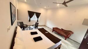 une chambre avec un lit, une table et des chaises dans l'établissement La Nature Retreat, à Kuilapayam