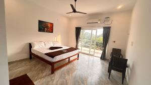 une chambre avec un lit et une grande fenêtre dans l'établissement La Nature Retreat, à Kuilapayam 45 autres photos