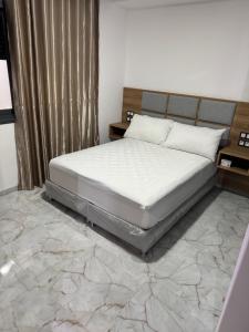 a bed in a bedroom with a marble floor at Hôtel kairouan in Fez