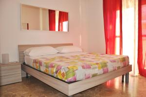 a bedroom with a bed with a mirror and red curtains at Viale Repubblica 307 4 in Pietra Ligure