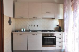 a kitchen with white cabinets and a stove top oven at Viale Repubblica 307 4 in Pietra Ligure