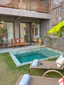 ein Swimmingpool mit zwei Stühlen und einem Haus in der Unterkunft Zami 03 & 04 in Pôrto de Pedras
