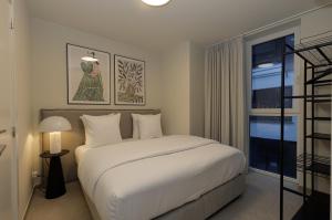 a bedroom with a white bed and a window at X-Corner Ostend - Casselbergh Residences in Ostend