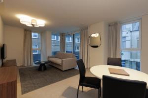 a living room with a table and a chair at X-Corner Ostend - Casselbergh Residences in Ostend