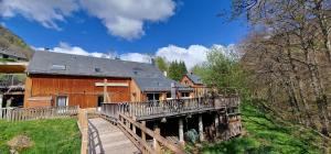 een huis met een houten brug ervoor bij A Cœur d'Hêtre in Estaing