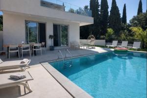 a swimming pool in front of a house at Villa Harmony Luxury Resort in Corfu
