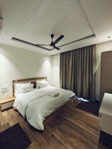 een slaapkamer met een groot bed met een plafondventilator bij D-LITE COTTAGE in Mahabaleshwar