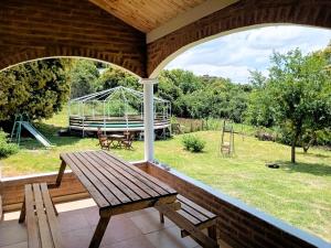 a porch with a wooden bench and a swing at Cabañas Las Pasionarias in Tanti +11 photos