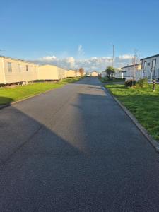 an empty road in a residential neighborhood with houses at Lyon's Robin Hood Rhyl 8 Berth Caravan in Rhyl