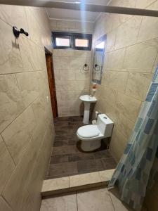 a bathroom with a toilet and a sink at Hotel El Alero in Chimaltenango