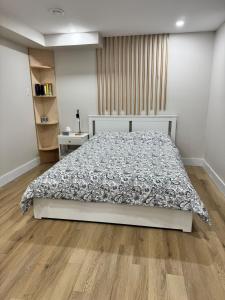 una camera da letto con un letto e un pavimento in legno di New Modern Private Suite Near Champlain Mall a Moncton