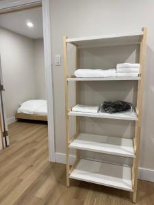 un armadio con scaffali bianchi e un letto in una stanza di New Modern Private Suite Near Champlain Mall a Moncton